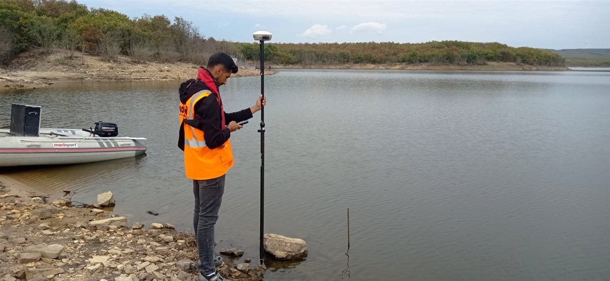 Kordil personelinin göl kıyısında GNSS ile topoğrafik arazi ölçümü