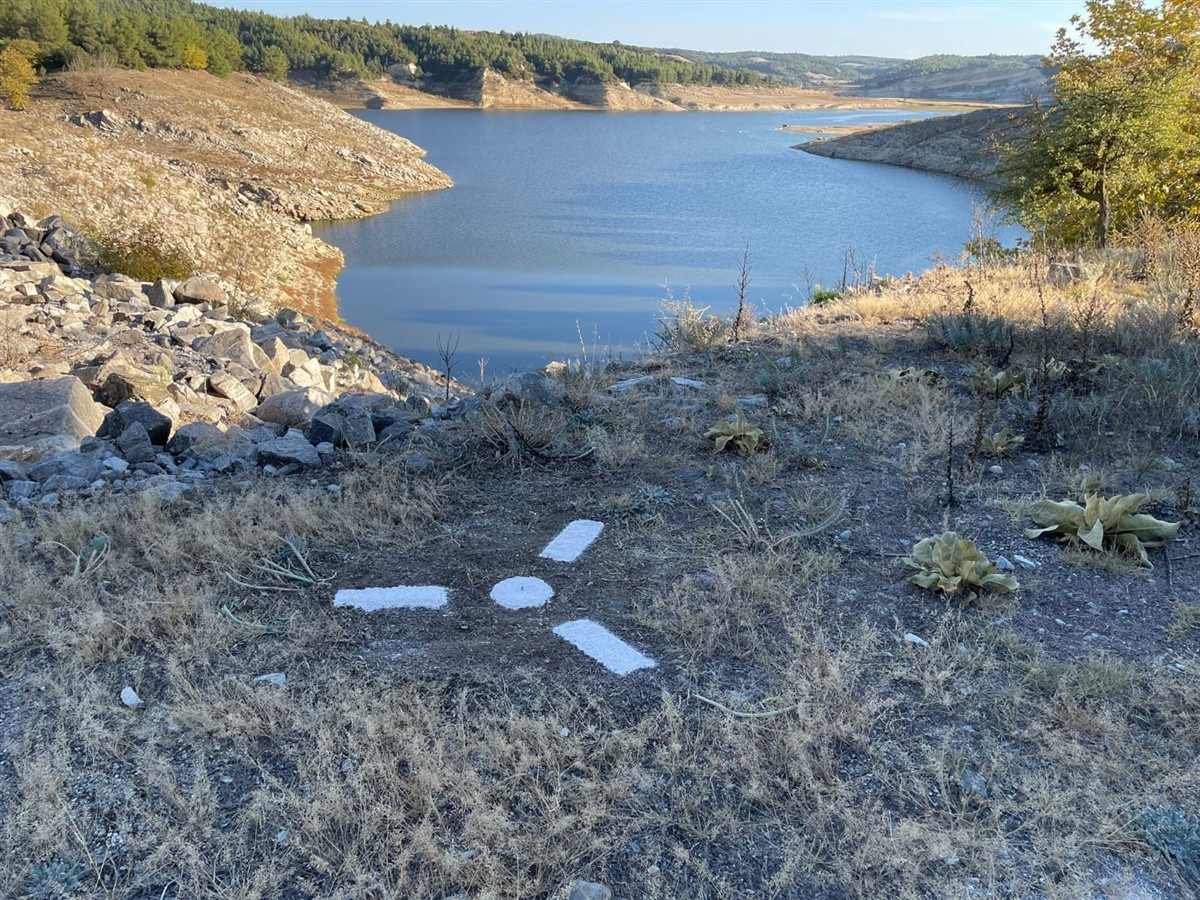Marked photogrammetry ground control point beside a reservoir