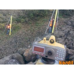 Saha ölçümleri sırasında ölçmeci ve jeodezik cihaz